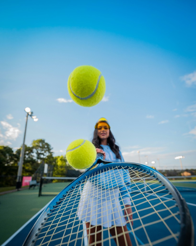 Tennis player on court with racket and balls in the foreground